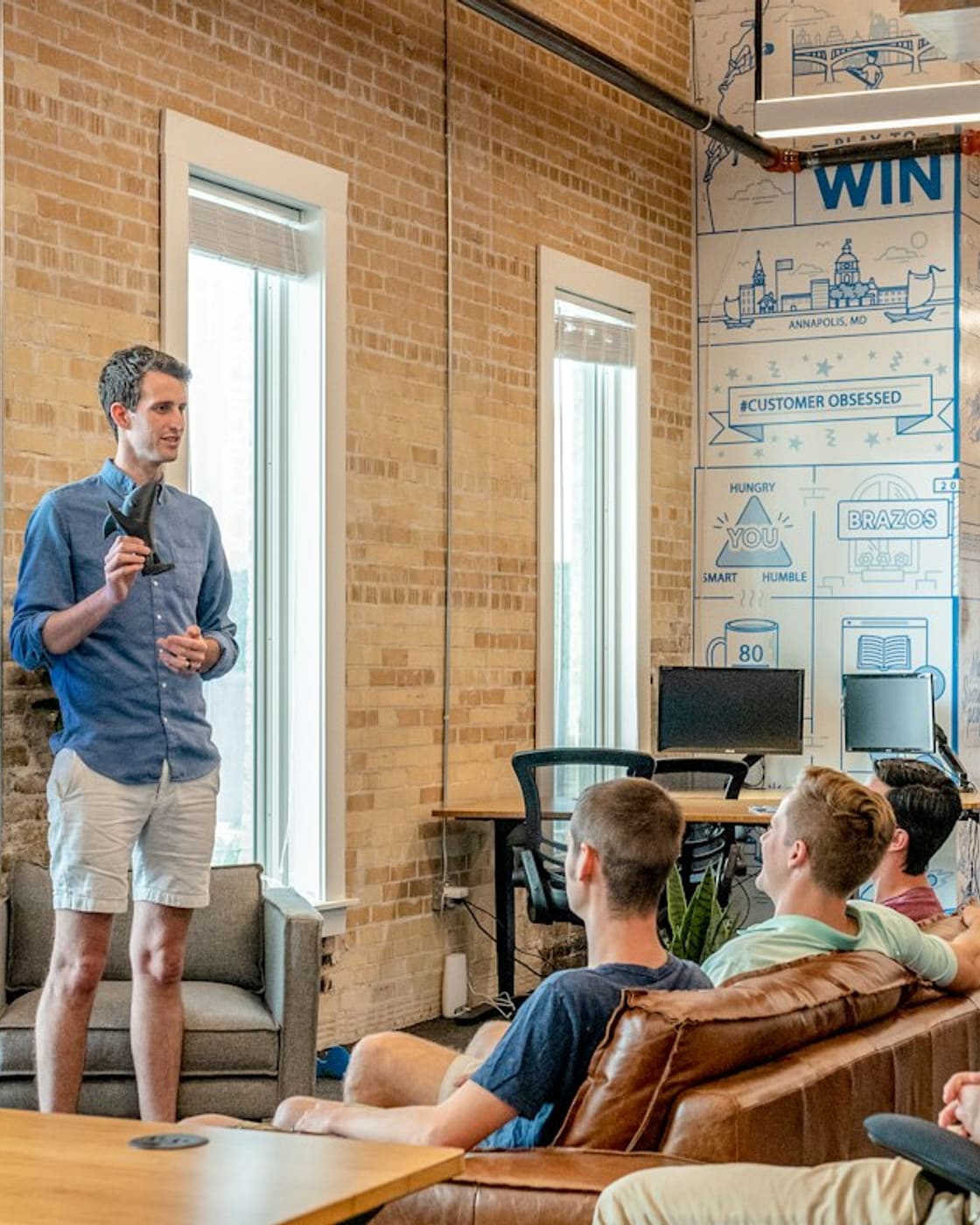 Technology leader presenting to a team in an open-plan office