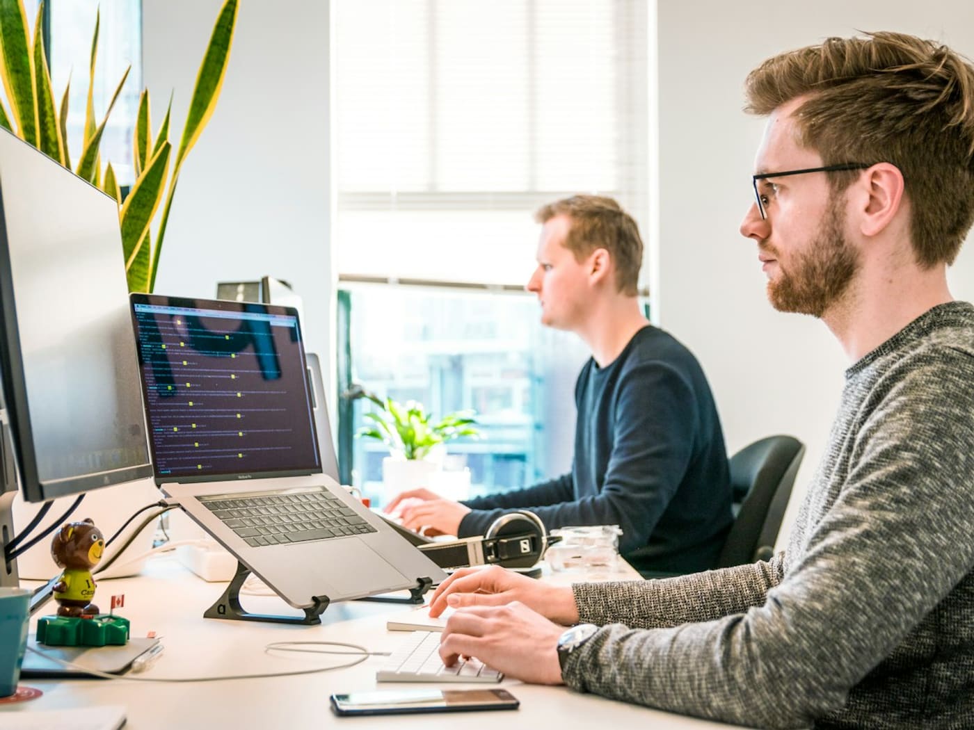 Two colleagues working side by side at a desk