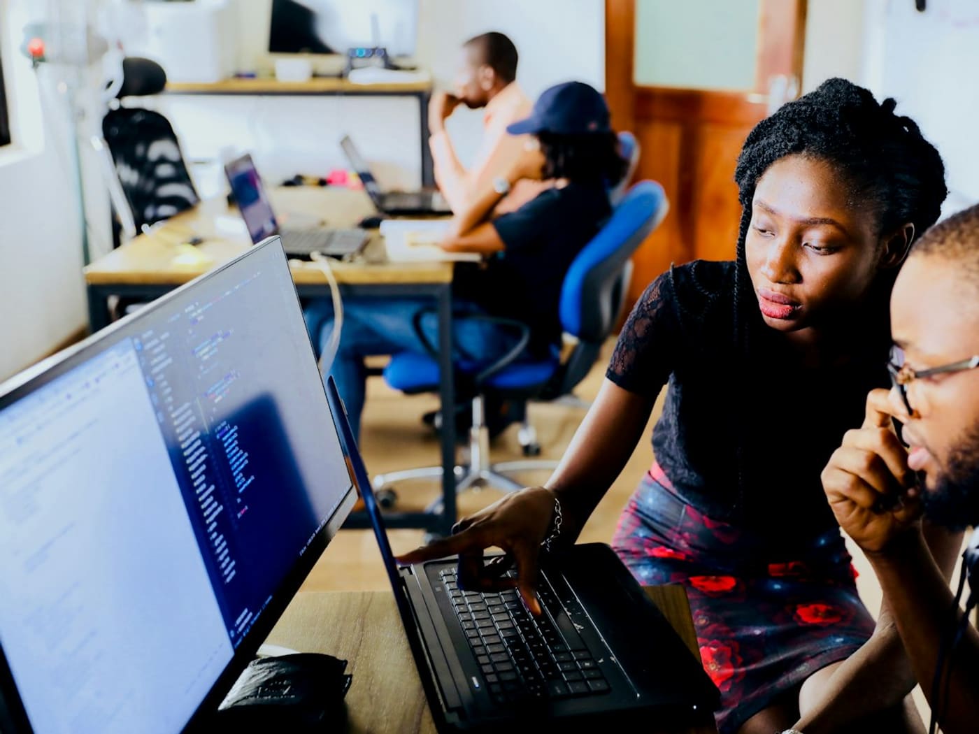 Two colleagues reviewing work together at a laptop
